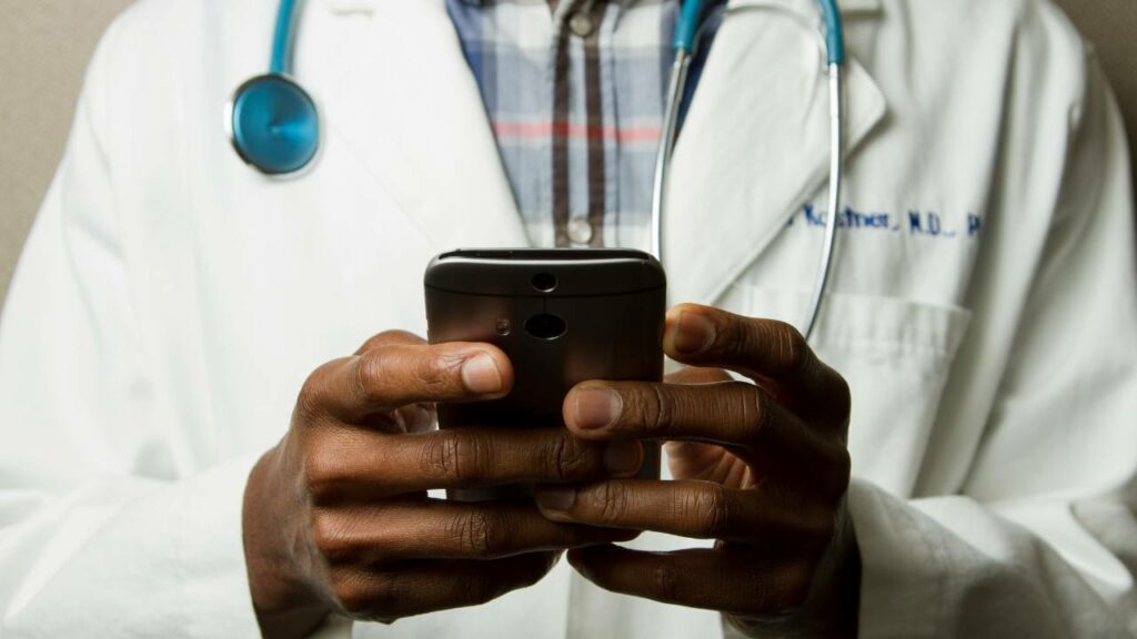A medical professional holding a smartphone